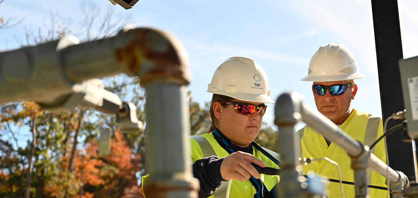 Two workers in safety PPE working on pipes